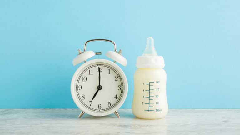 Photo of alarm clock and baby bottle